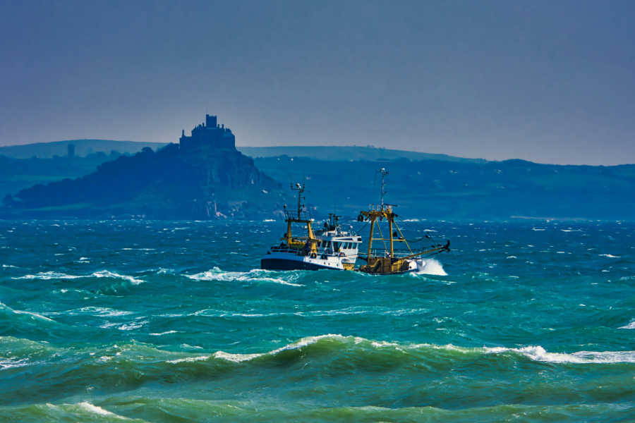 a trawler on the rough sea in front of St Michaels Mount - here is a top location for stormwatching in Cornwall